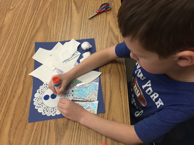 kindergarten student making a snowy day collage