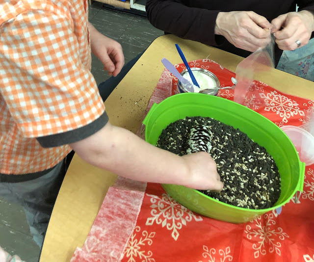 making pine cone bird feeders at a winter themed center