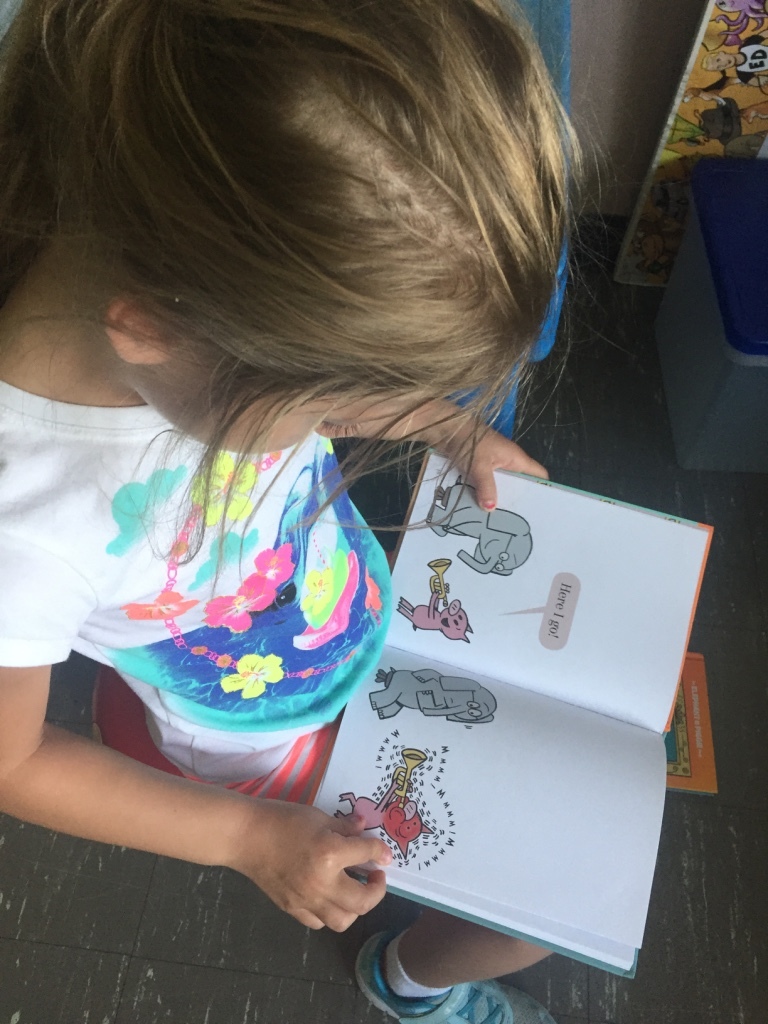 child reading a book in kindergarten